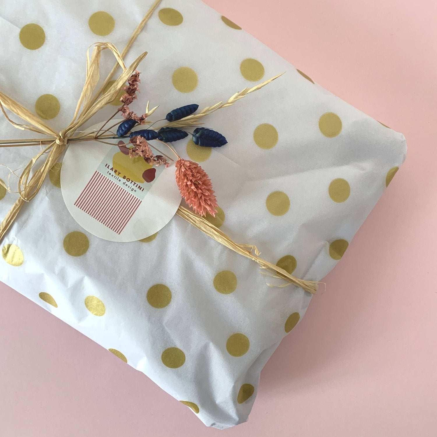 Pacchetto regalo in carta con raffia e fiori essiccati e etichetta adesiva di Ilary Bottini