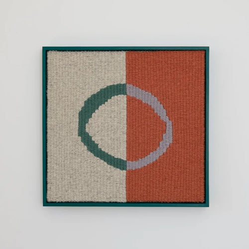 Opera tessile incorniciata Aura di Ilary Bottini, opera di fiber art in lana con base grigia e mattone e cerchio irregolare verde e grigio, cornice in legno dipinta di verde