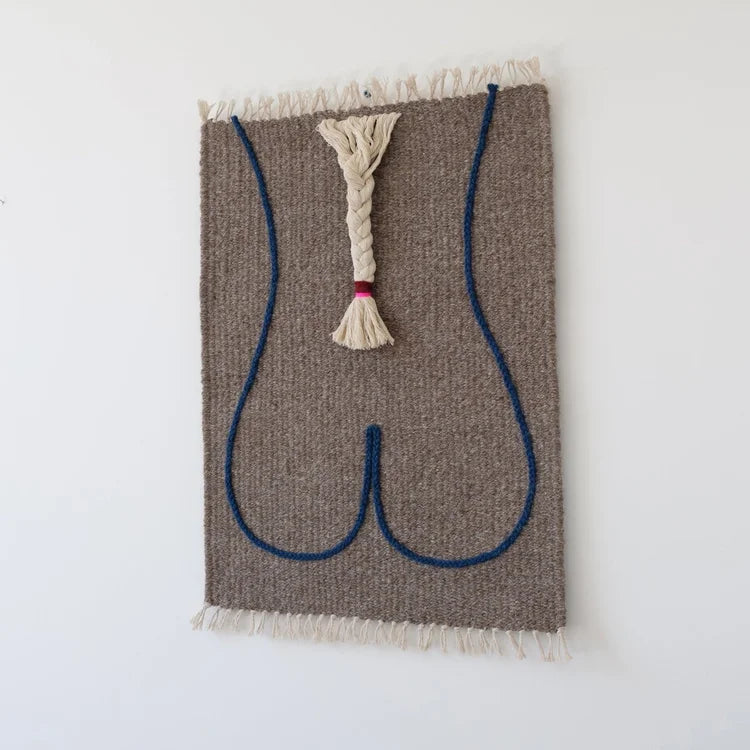 Arazzo contemporaneo in lana su base in cotone di Ilary Bottini con composizione astratta: profilo del corpo femminile tracciato in filo blu su tessuto grigio e treccia centrale in lana bianca.