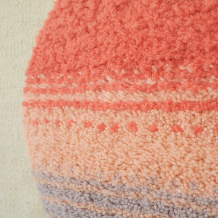 Arazzo contemporaneo Patagonian Sun di Ilary Bottini, opera tessile in lana tessuta a telaio verticale con base beige e cerchio annodato rosso, rosa e lilla
