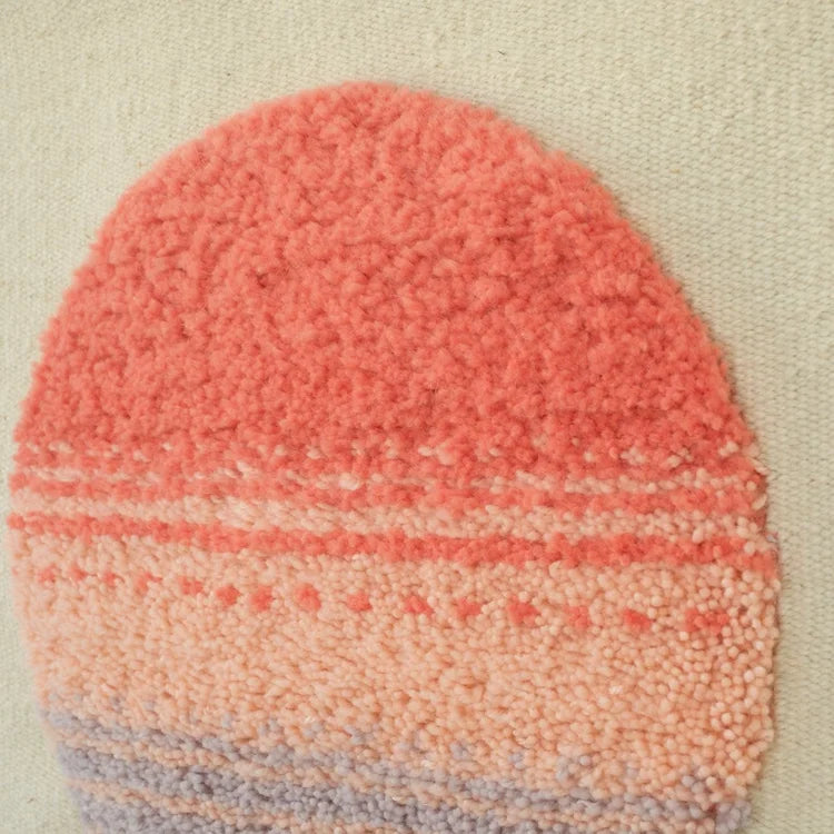Arazzo contemporaneo Patagonian Sun di Ilary Bottini, opera tessile in lana tessuta a telaio verticale con base beige e cerchio annodato rosso, rosa e lilla