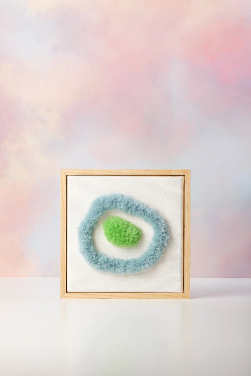 Opera di fiber art incorniciata Zen Garden Aarhus di Ilary Bottini, tela bianca in cotone con elementi in verde e azzurro